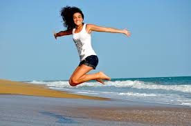 Mujer saltando en la orilla de la playa llena de vitalidad dado que lleva una alimentación sana y se encuentra fuerte de ánimo. Como tratar la ansiedad, como tratar la depresión, tratar el estrés, alimentación sana, relación del nervio vago con la ansiedad, como cuidar el nervio vago, técnicas de relajación.