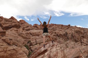 Mujer subiendo una montaña con las manos levantadas como demostrando que lo que te propongas lo consigues. Como tratar la ansiedad, como tratar la depresión, tratar el estrés, alimentación sana, relación del nervio vago con la ansiedad, como cuidar el nervio vago, técnicas de relajación.