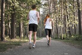 Foto de una pareja chico y chica corriendo por un camino a través de muchos árboles. Como tratar la ansiedad, como tratar la depresión, tratar el estrés, alimentación sana, relación del nervio vago con la ansiedad, como cuidar el nervio vago, técnicas de relajación.