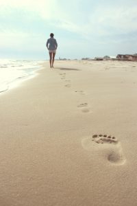 Foto de una mujer de espaldas que va andando por la orilla de la playa. Como tratar la ansiedad, como tratar la depresión, tratar el estrés, alimentación sana, relación del nervio vago con la ansiedad, como cuidar el nervio vago, técnicas de relajación, salud.  